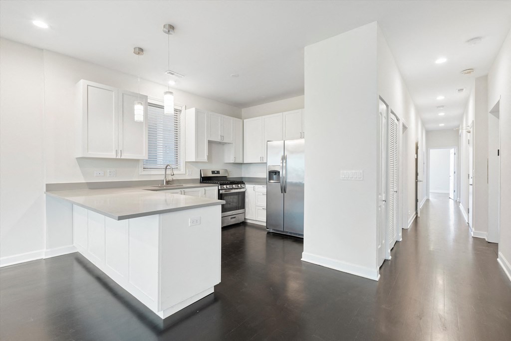 a kitchen with white cabinets and stainless steel appliances