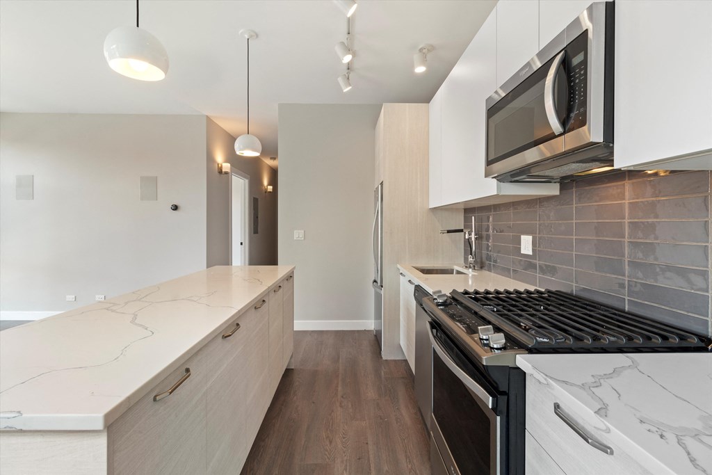 a kitchen with white cabinets and a stove and a microwave