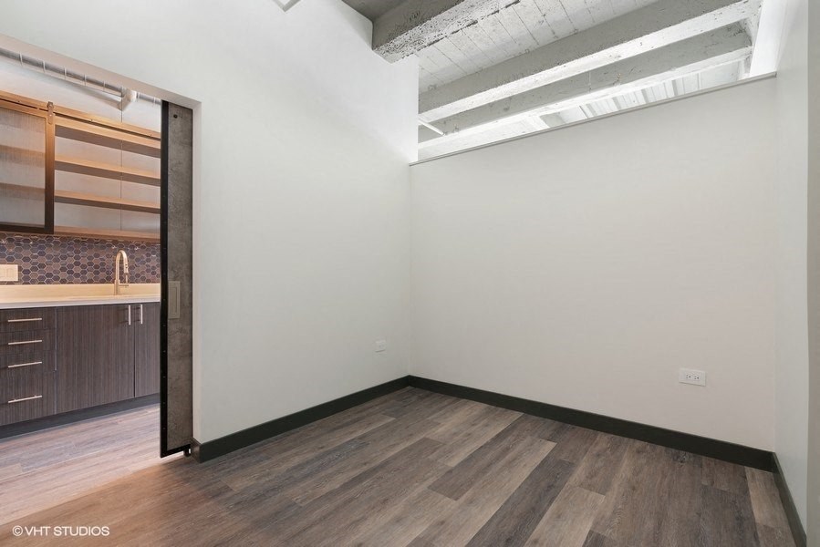 an empty room with a sink and a mirror