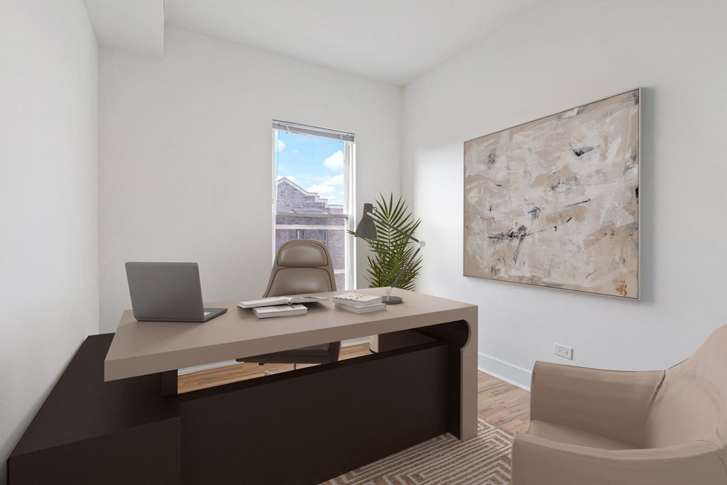 an office with a desk and a laptop and a window