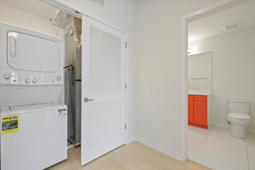 a laundry room with a washer and dryer and a bathroom with a toilet