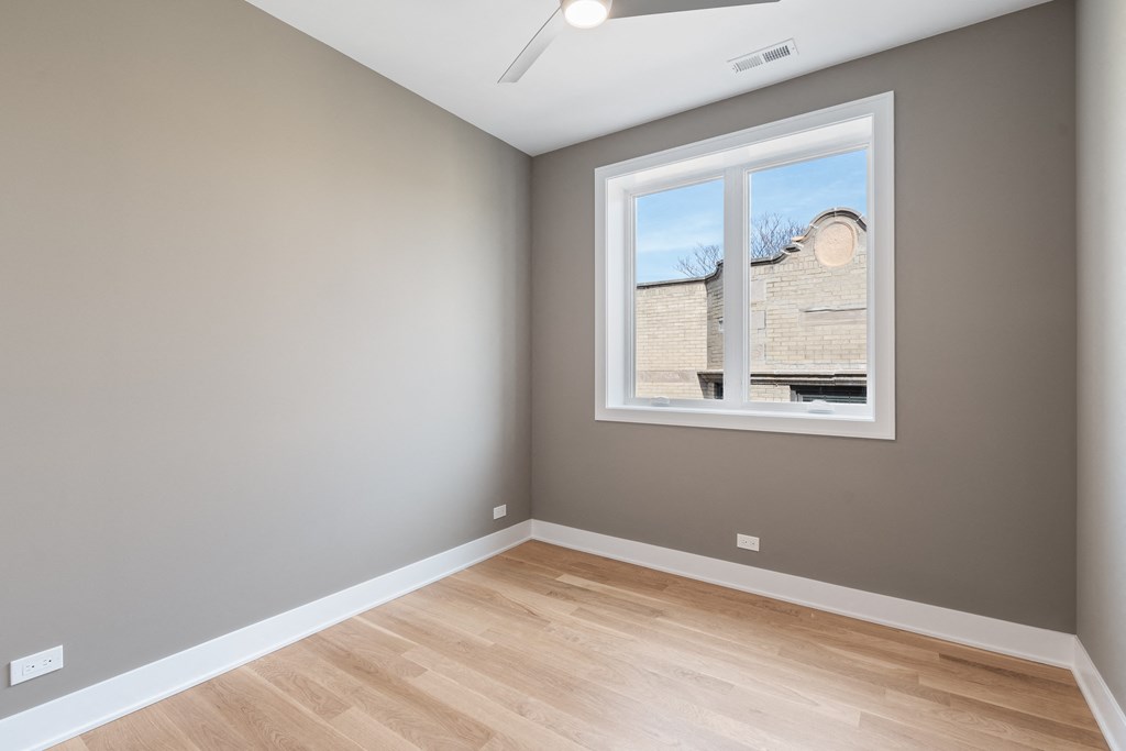 an empty room with wood floors and a window