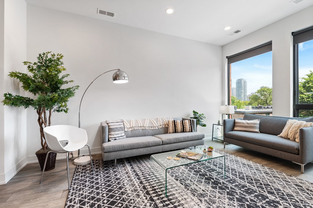 A living room with two couches a coffee table and a large window