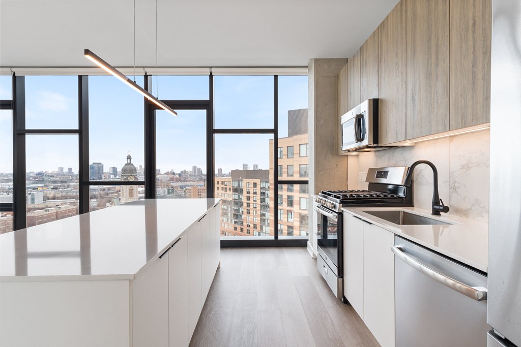 a kitchen with a large window and a sink and a stove