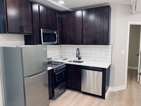 A kitchen with dark wood cabinets and stainless steel appliances.
