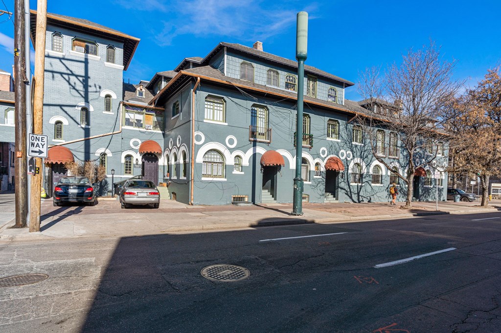 a city street with a blue building on the corner of a street