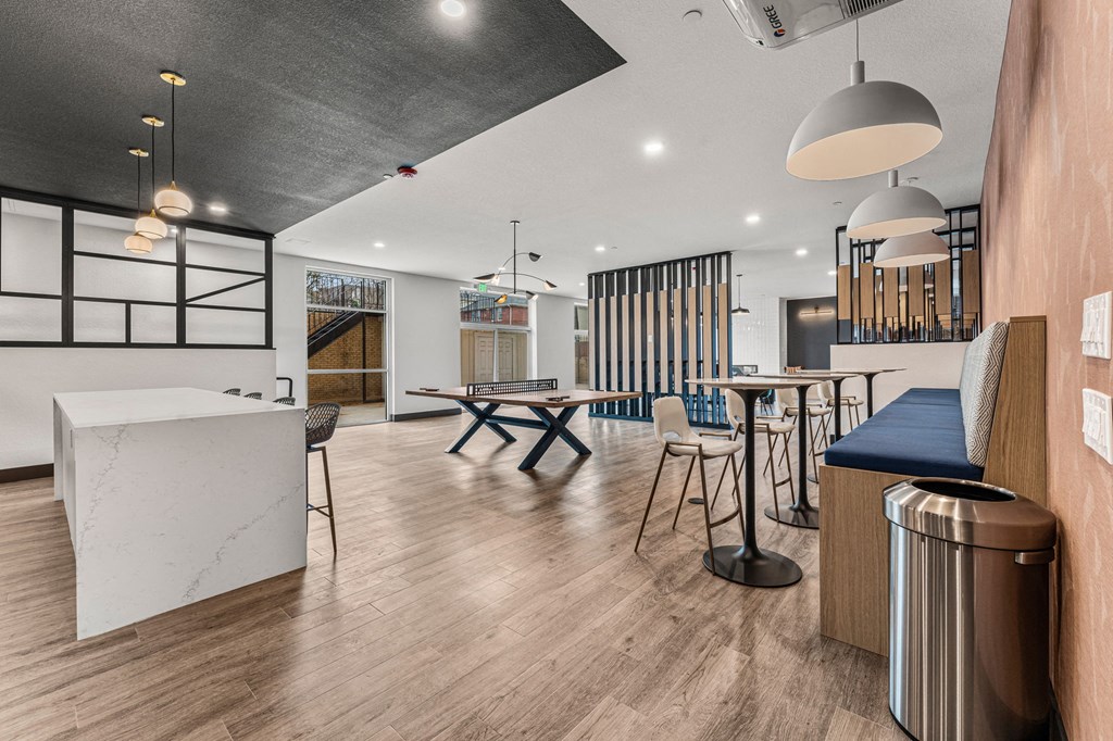 a kitchen and dining area with a table and chairs and a bar with stools