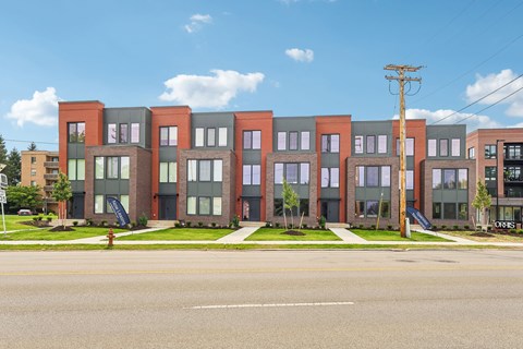 A row of multi-story apartment buildings with a fire hydrant in front of the first one.
