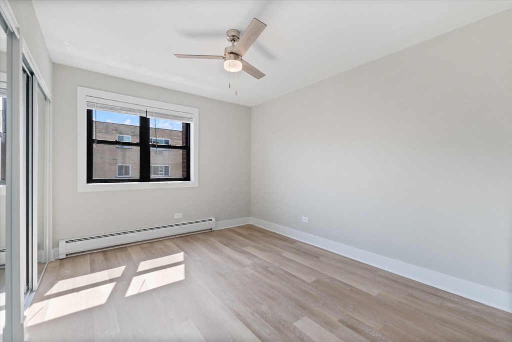 a bedroom with hardwood floors and a ceiling fan