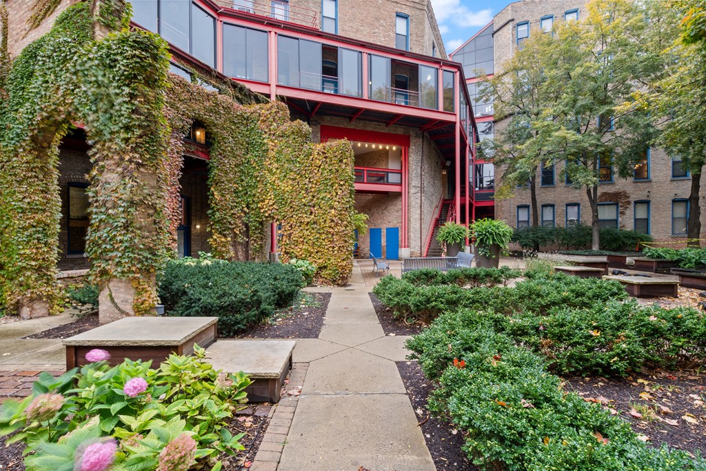 the courtyard of a building with plants and a sidewalk