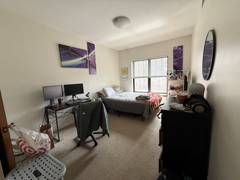 A bedroom with a bed, desk, and chair.