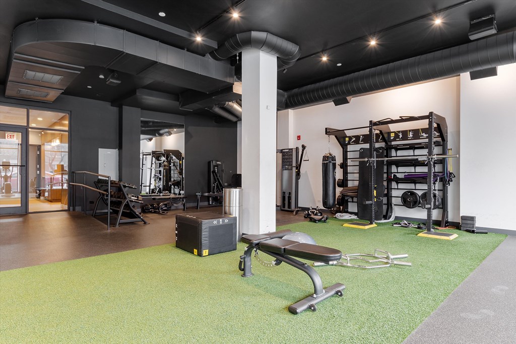 a gym with green carpet and exercise equipment