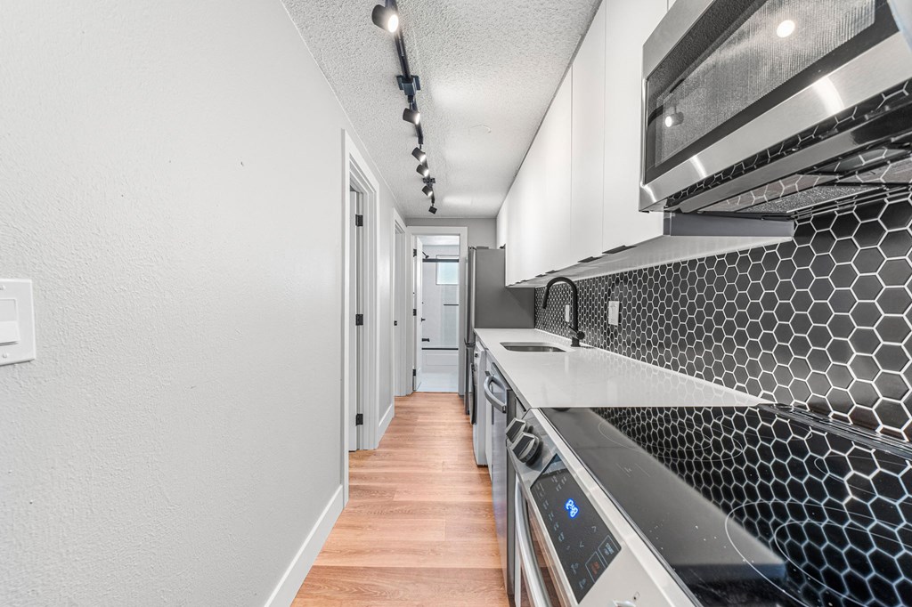 a kitchen with white cabinets and a wood floor