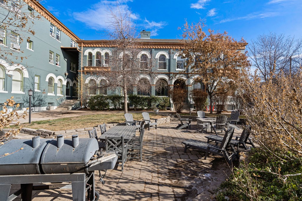 a courtyard with tables and chairs in front of a building
