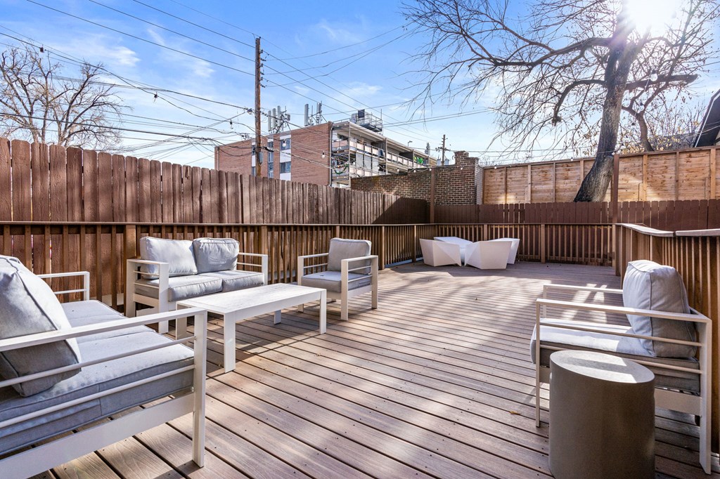 the deck on the top of the building has couches and chairs