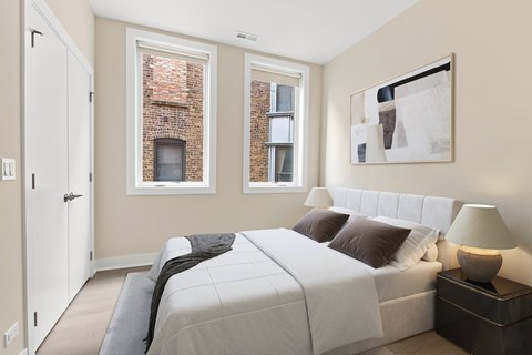 A bedroom with a large bed and a painting on the wall.