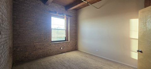 A room with a brick wall and a window.