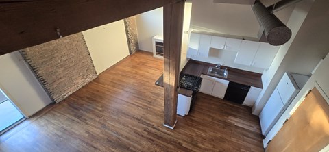 A kitchen with a wooden floor and white walls.