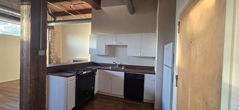 A kitchen with white cabinets and black appliances.