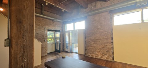 A room with a wooden floor and a brick wall.