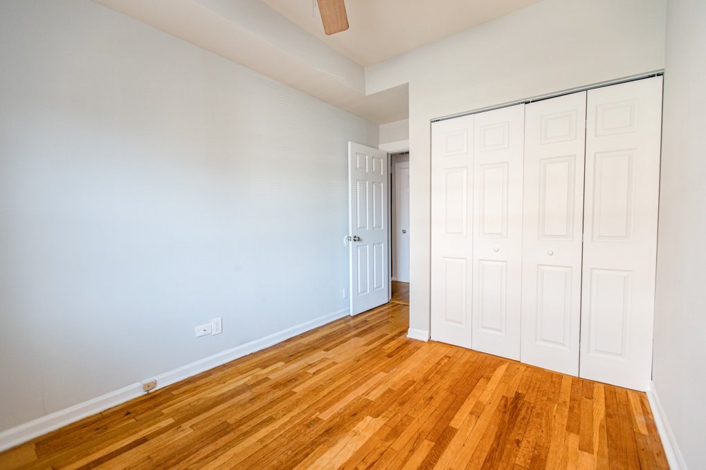 A room with a white wall and a wooden floor.