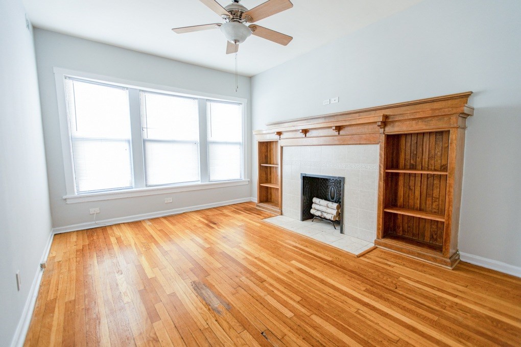 A room with a fireplace and wood flooring.