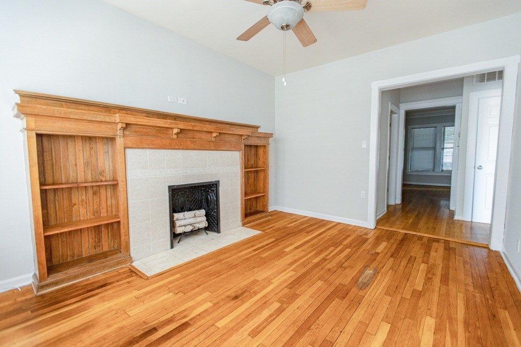 A room with a fireplace and wood flooring.