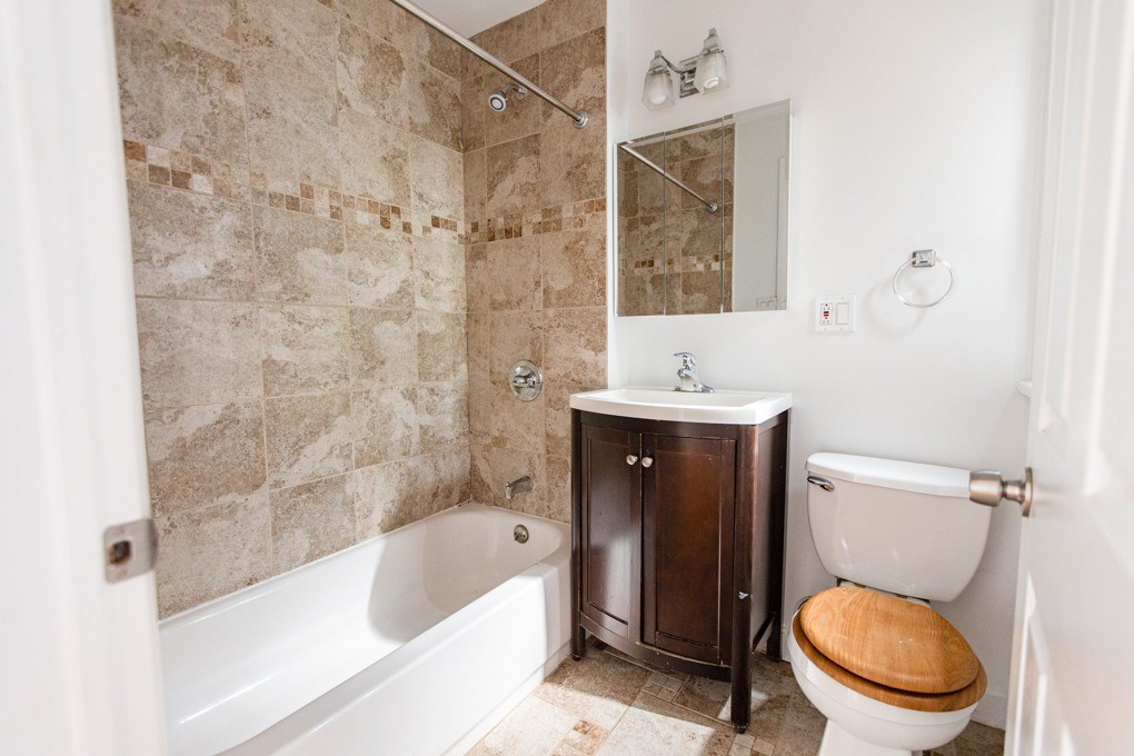 A bathroom with a white toilet and a tiled shower area.