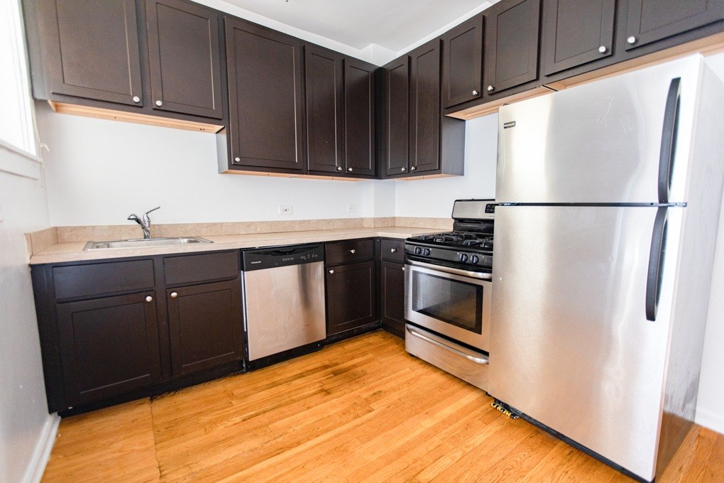 A kitchen with a stainless steel refrigerator, dishwasher, and oven.