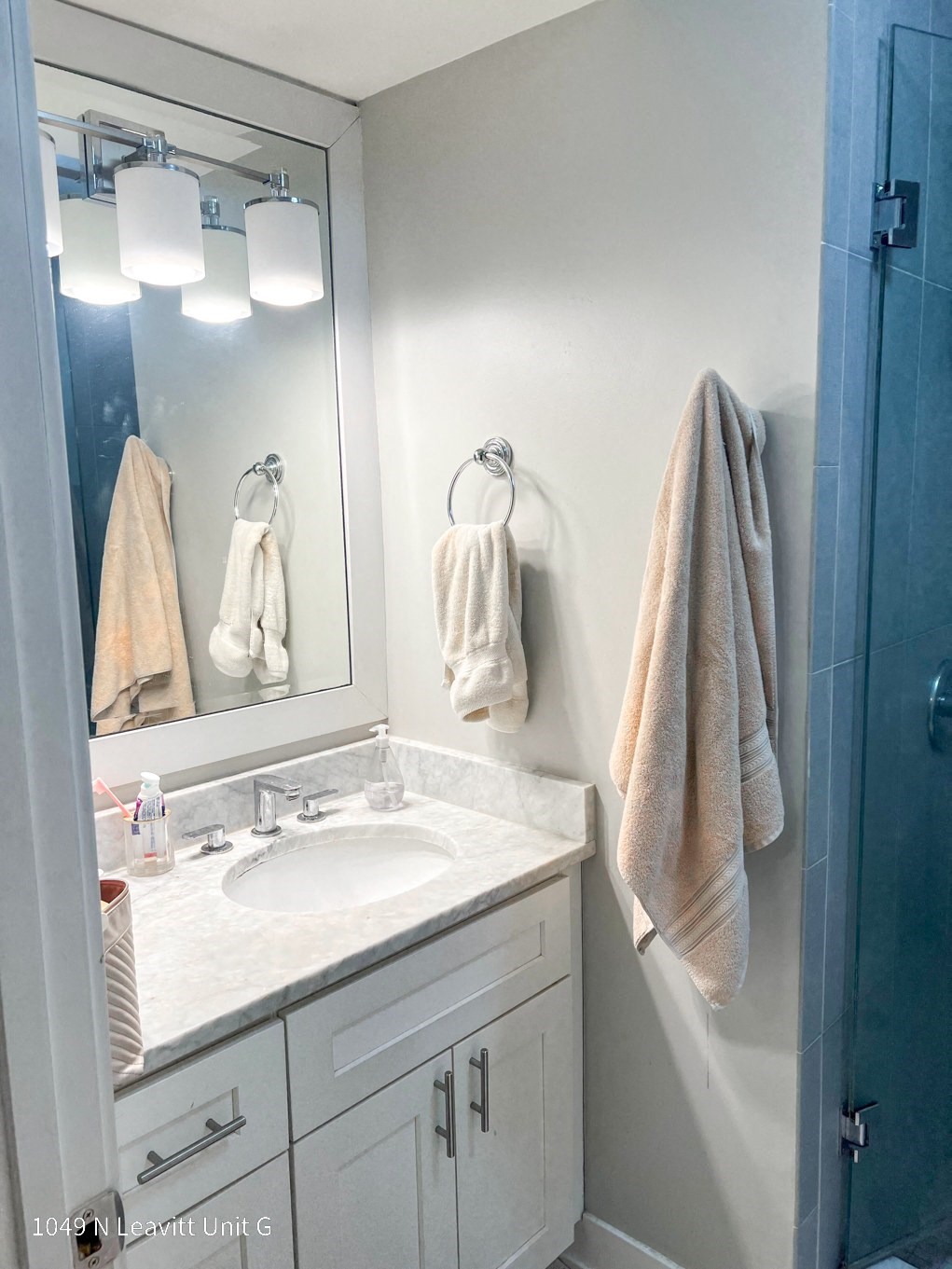 a small bathroom with white cabinets and a white sink