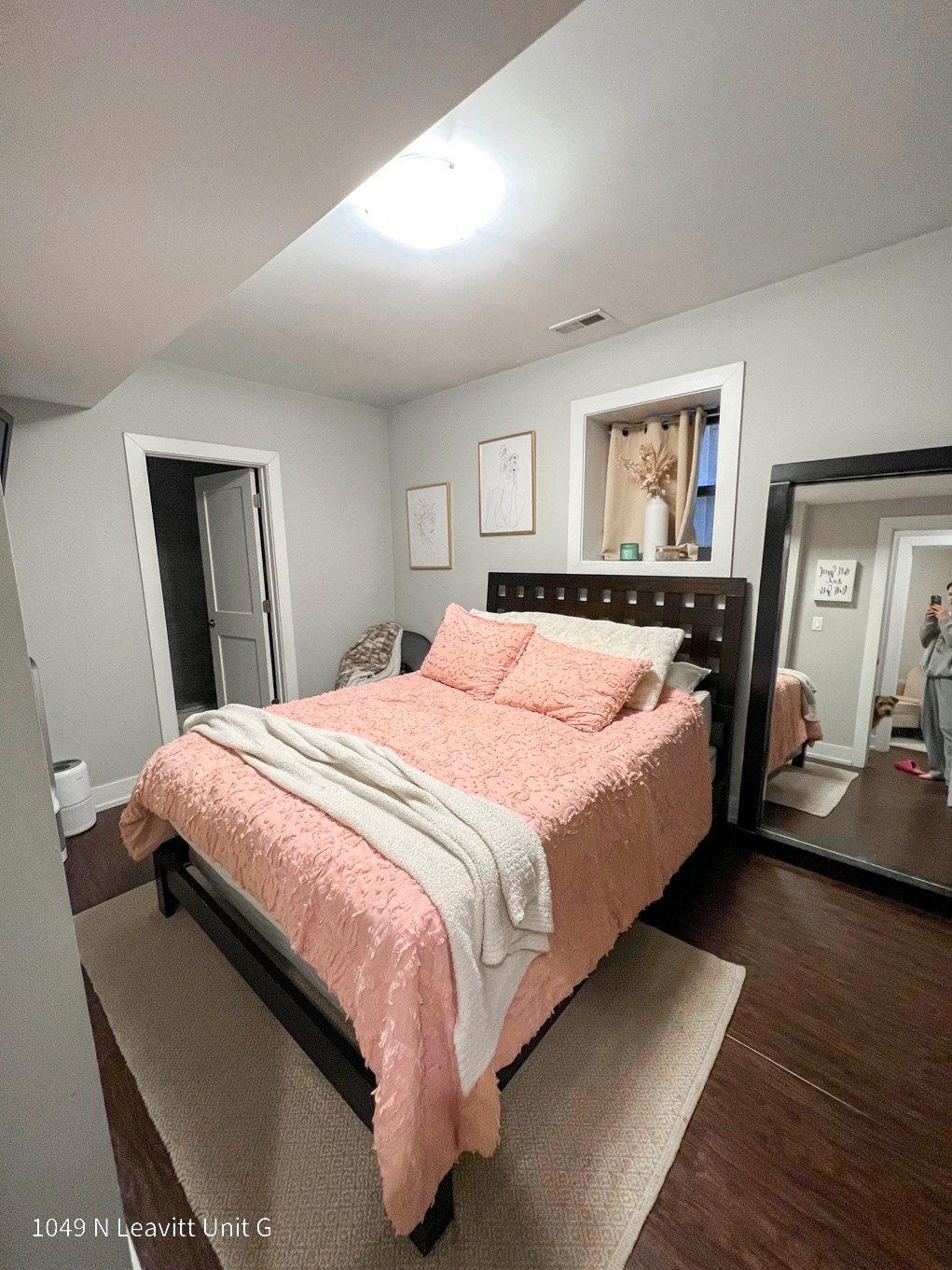 a bedroom with gray walls and a pink bedspread
