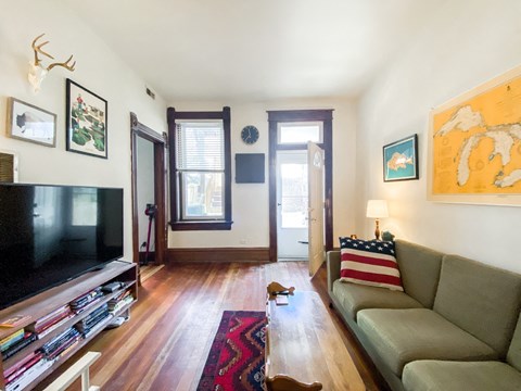 A living room with a couch, television, and a rug.