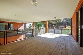 a large balcony with wood floors and glass doors
