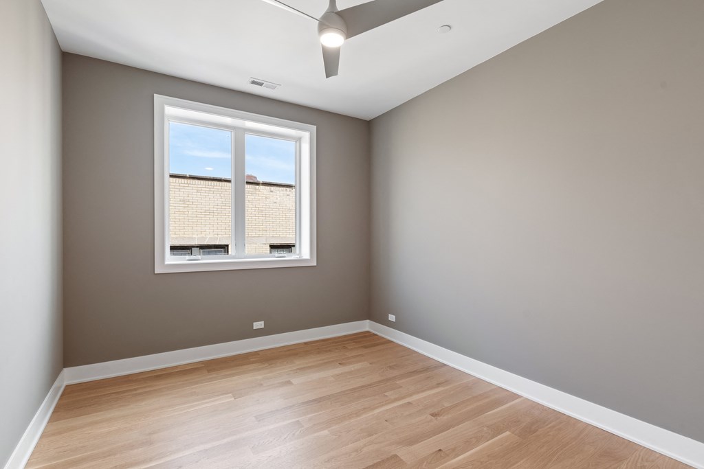 an empty room with wood floors and a window