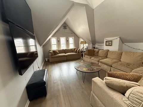 A living room with a large couch and a television.
