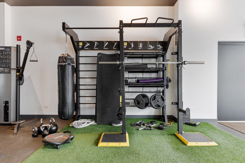 a home gym with a loft bed and weights on the floor