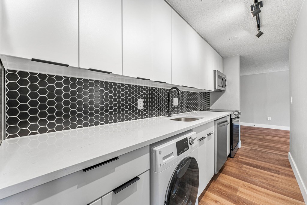 a laundry room with white cabinets and a white washer and dryer