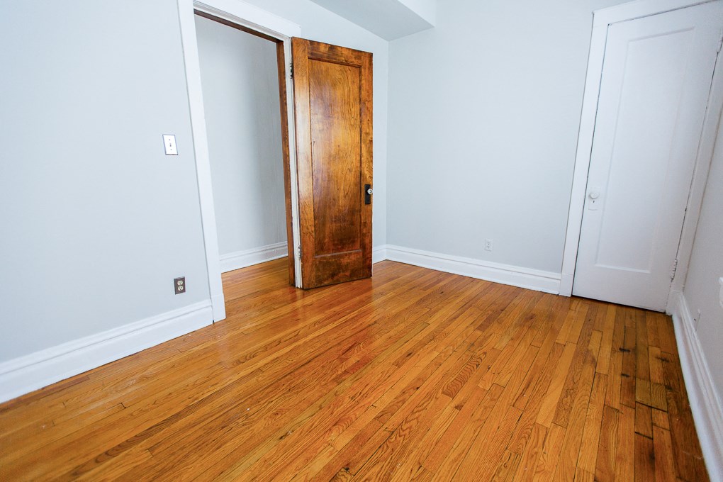 a room with a wooden floor and a wooden door