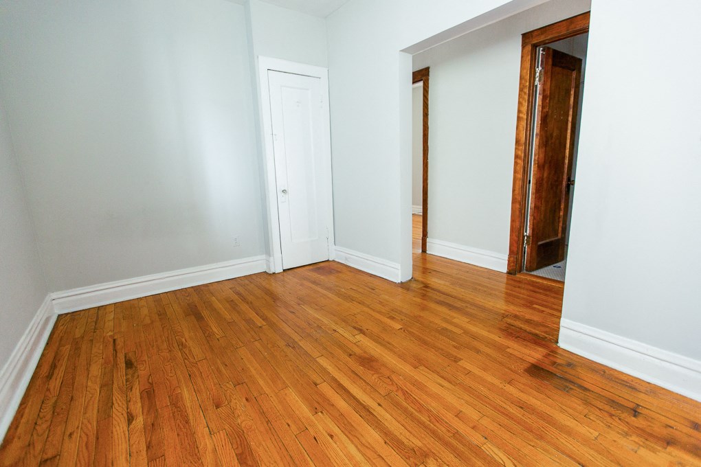 an empty room with wooden floors and a closet
