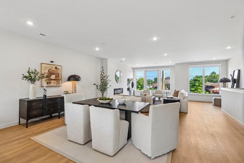 A modern dining room with a black table and white chairs.