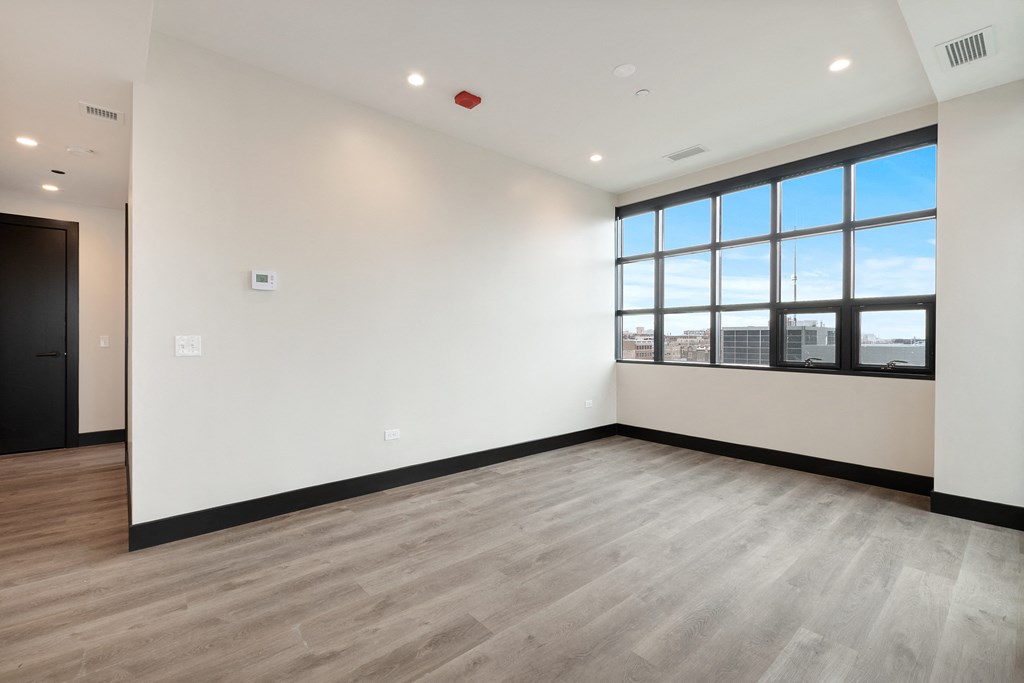 an empty room with white walls and a window