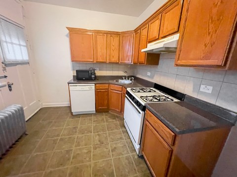 A kitchen with brown cabinets and a black stove top.