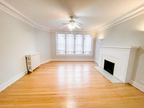 A room with a fireplace and a ceiling fan.