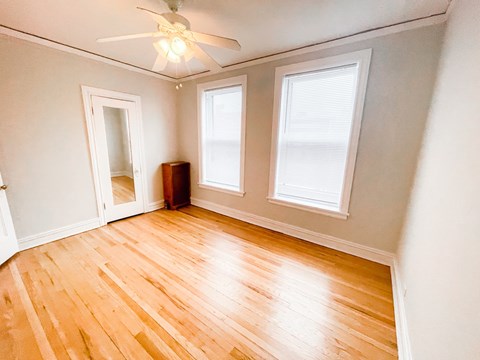 A room with a wooden floor and a ceiling fan.