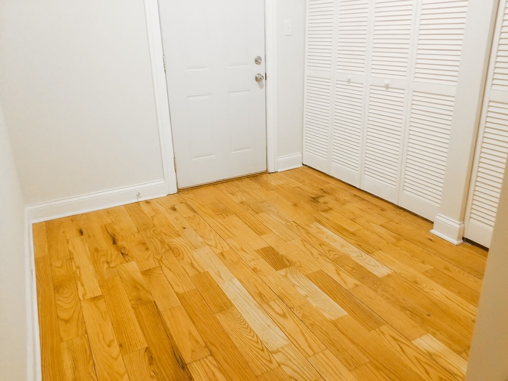 a room with wooden floors and white closet doors