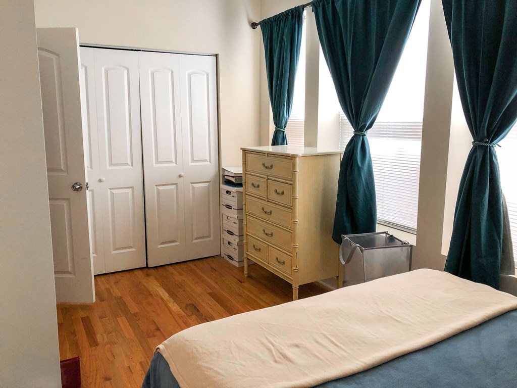 A bedroom with a bed, dresser, and wardrobe.