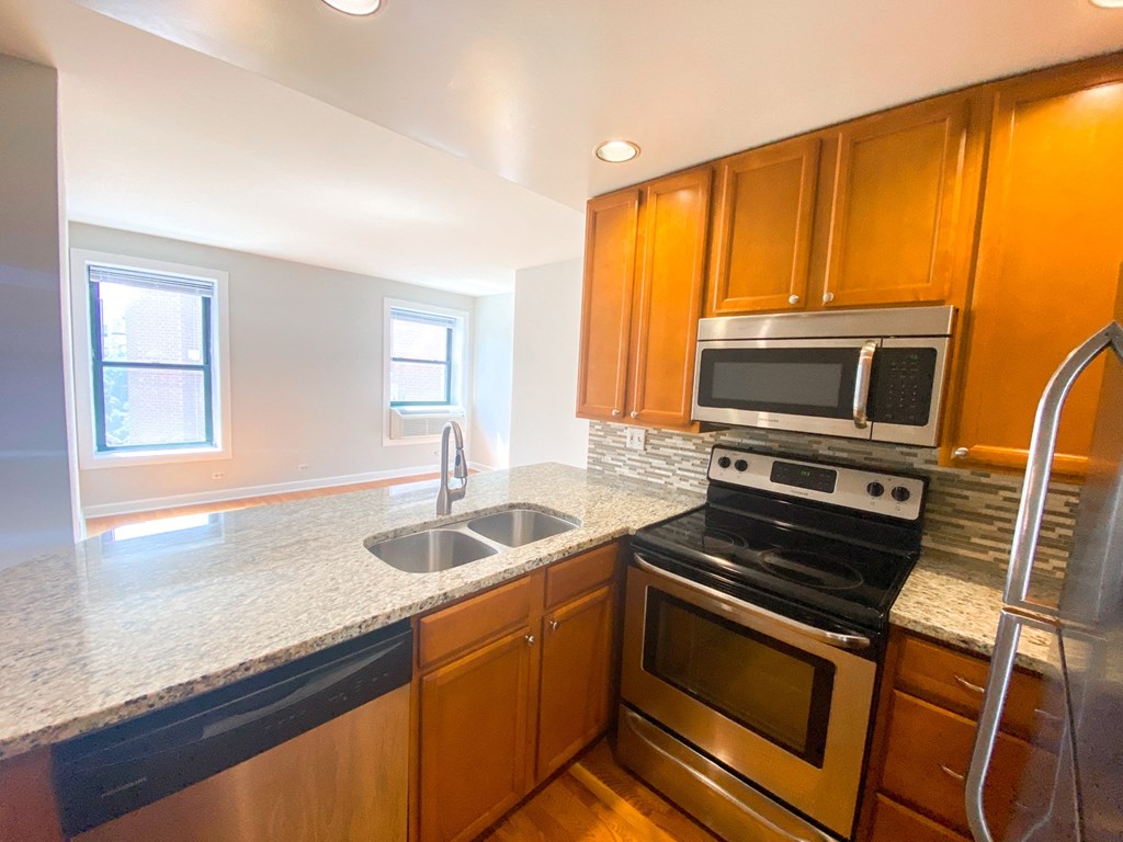 a kitchen with wooden cabinets and stainless steel appliances