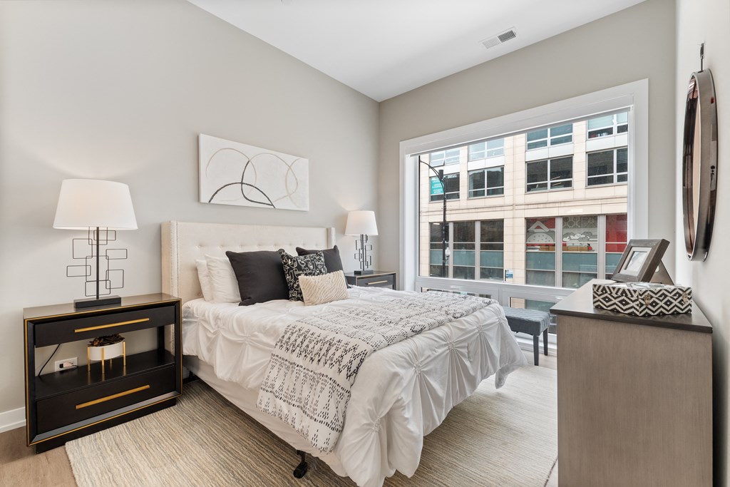 a bedroom with a bed and a large window