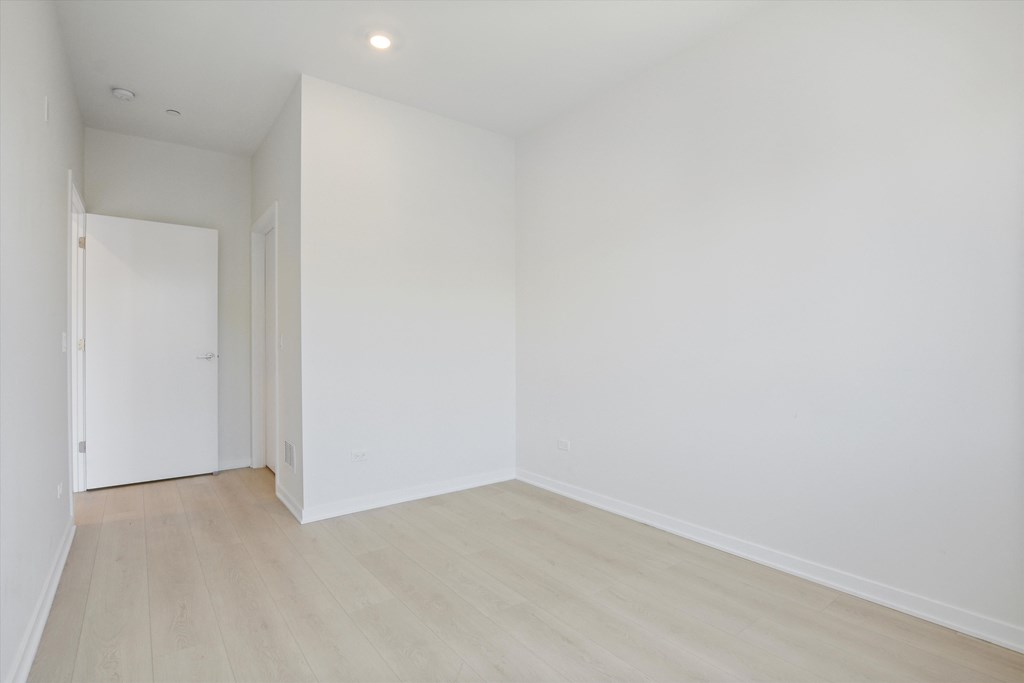 an empty room with white walls and wood floors