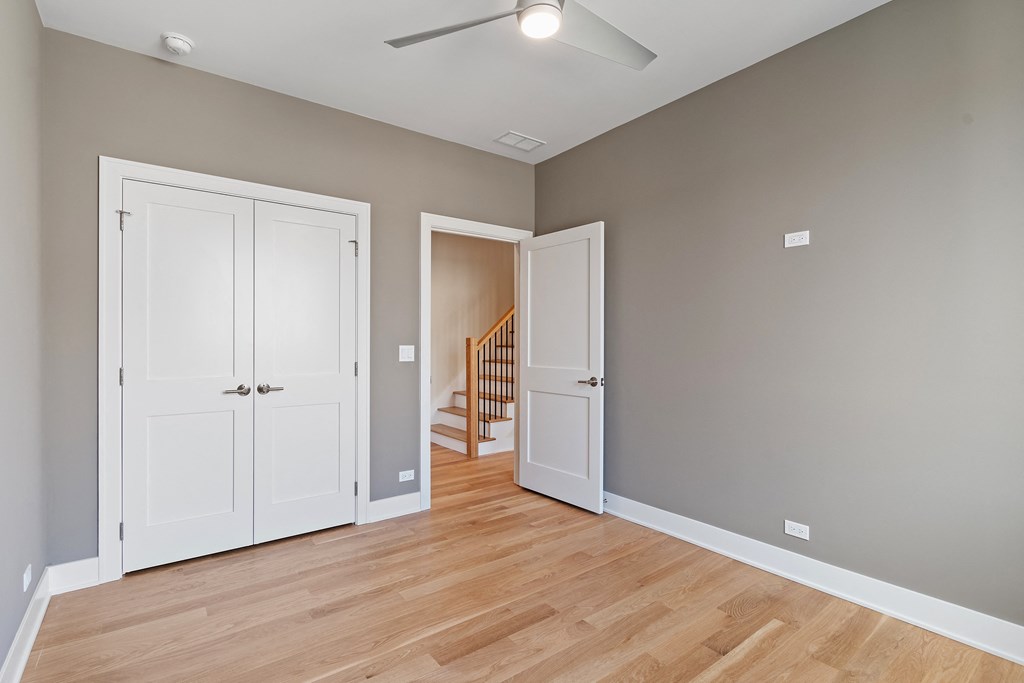 an empty living room with two doors and a staircase